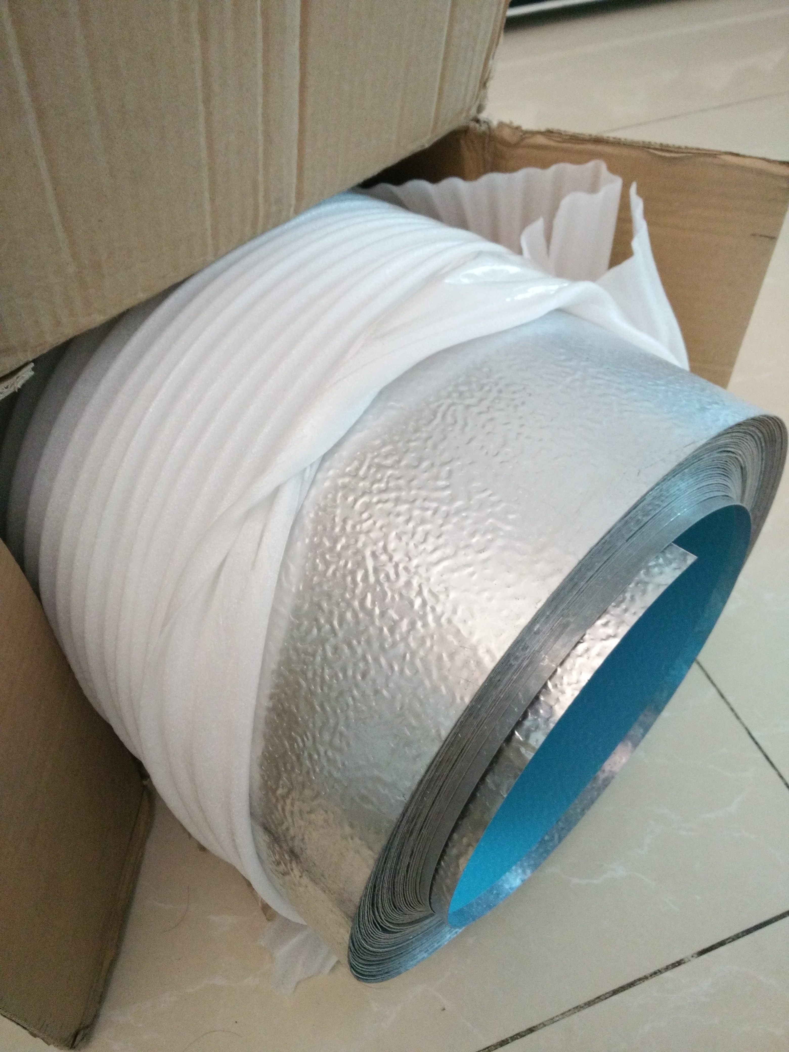 Stucco embossed aluminum jacketing roll